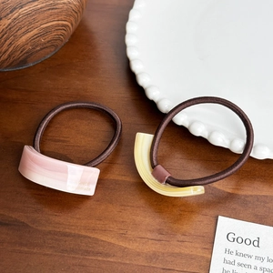 Minimalist resin ponytail holders in pink and yellow on brown elastic hair ties