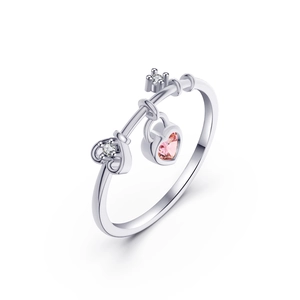 Silver metal ring with pink heart gem pendant and key element on white background