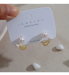 Detailed view of luxury gold pearl earrings with 925 silver post on jewelry card