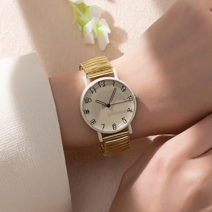 Detailed view of women's quartz watch with gold elastic band and hand-drawn numerals
