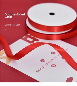 Close-up of premium double-faced red satin ribbon roll showing smooth texture and luster
