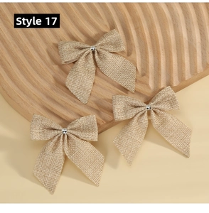 Set of three rustic burlap bows with coarse jute texture and silver metal fasteners