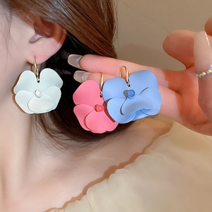 Detail of floral earrings in white pink and blue with matte petals and gold hooks
