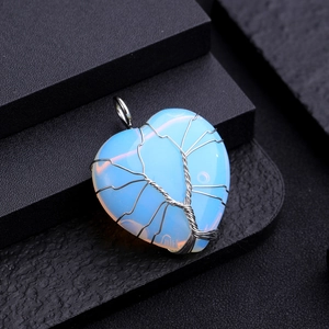 Macro detail of Tree of Life wire wrapped on heart-shaped translucent white gemstone
