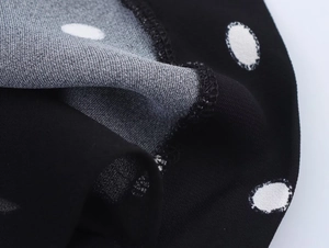 Dettaglio macro del tessuto a pois in chiffon con cuciture di qualità e drappeggio
