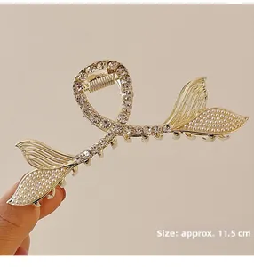Detail view of a large mermaid tail hair claw clip with pearls and sparkling rhinestones