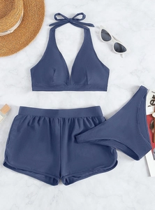 Flat lay of three-piece fog blue bikini set with halter top and high-waisted boy shorts
