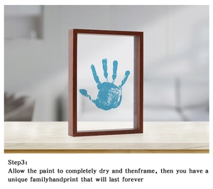 Detail of wooden DIY frame with a blue handprint on double transparent panels