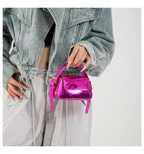 Detail view of mini pink patent leather handbag with glossy metallic finish and top handle