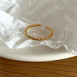 Elegant gold twisted rope ring with adjustable open band on a minimalist background