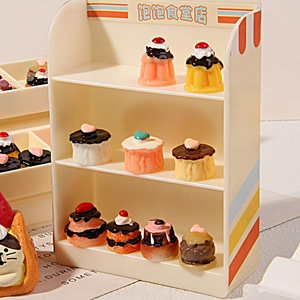 Miniature resin chocolate vanilla cake figurines on a 3-tier toy display stand