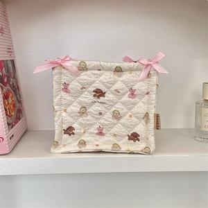 Close-up of quilted storage basket with cute animal prints and pink satin bows