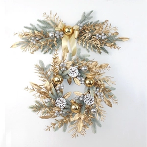 Golden and silver Christmas wreath set with pine cones and ribbons on white backdrop