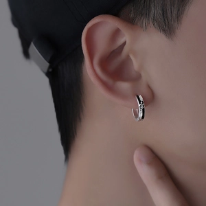 Men's retro silver and black knight earrings with vintage floral relief worn on ear