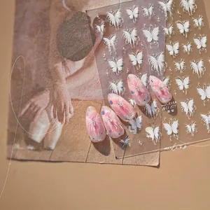 Macro shot of white butterfly nail art stickers model MS 871 on elegant pink gradient nails