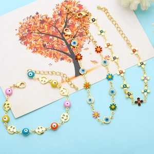 Detail of gold-plated bracelets featuring colorful enamel charms and evil eye pendants