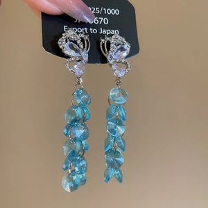 Vue détaillée des boucles d'oreilles papillon en argent 925 avec glands en cristal bleu