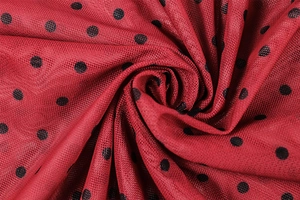 Macro detail of red mesh fabric with black polka dots featuring soft spiral pleats
