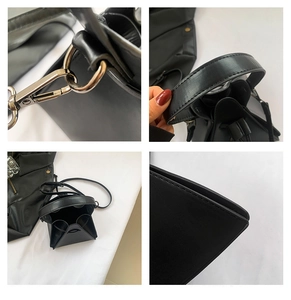 Detail view of black punk triangle handbag featuring silver hardware and PU leather texture