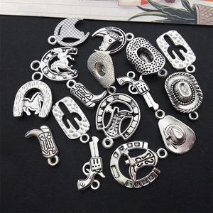 Macro shot of antique silver western charms including cowboy hats, boots and cactus for DIY