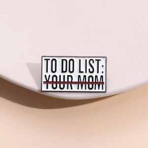 Détail d'un pin's émaillé avec texte humoristique To Do List Your Mom sur un présentoir