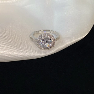 Detail of silver open ring featuring a large round zircon and double halo setting