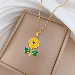 Close-up of a gold sunflower pendant with vibrant yellow petals and green leaves