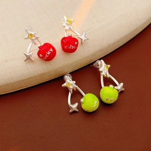 Detailed view of red and green cherry earrings with sparkling star gems and Lucky engraving