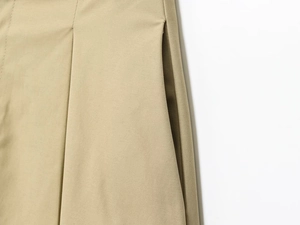 Dettaglio dei pantaloni in twill kaki con tasca laterale e cuciture a pieghe rifinite
