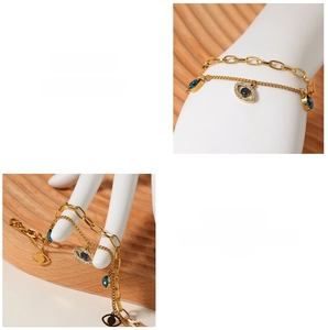 Detail of gold double-layer bracelet featuring blue evil eye and waterdrop charms