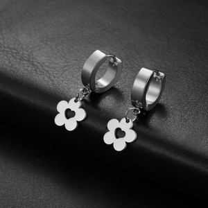 Detail of silver stainless steel flower hoop earrings with heart cutout on black leather