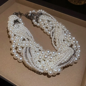 Detailed close-up of multi-layer pearl necklace with rhinestone accents in a jewelry box
