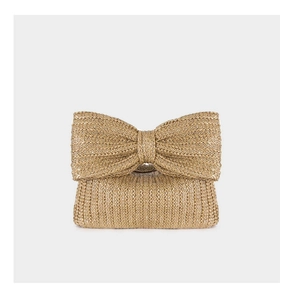 Detailed view of handmade straw handbag featuring a large decorative bow and woven texture