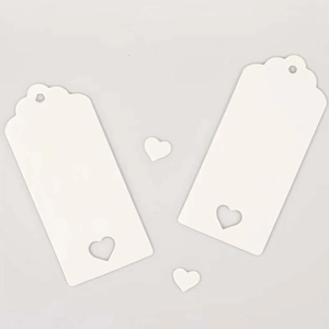 Close-up of white cardstock heart tags with scalloped edges and cutout heart design