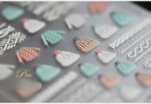Macro shot of 5D embossed sweater texture nail stickers with realistic 3D relief effects