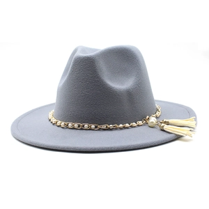 Detail of grey fedora hat featuring gold chain, pearl accents and hanging tassel charms