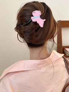 Vue détaillée d'une pince à cheveux chiot rose stylisée sur un chignon de femme