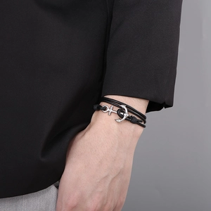 Detail of multi-layer black leather wrap bracelet with silver anchor clasp on wrist