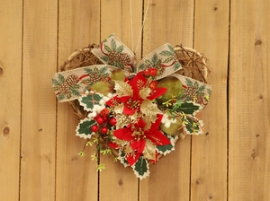 Close-up of heart-shaped Christmas wreath with pinecone ribbon and gold flowers