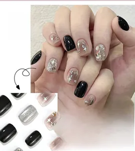 Detail of short square press-on nails featuring black gloss, silver glitter, and rhinestones