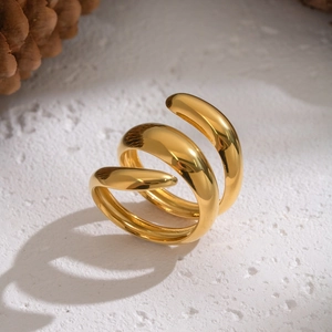 Dettaglio dell'anello a spirale placcato oro 18K su una base in pietra naturale testurizzata