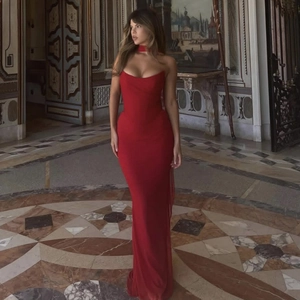 Detail of red tube top evening dress with matching neck accessory in a luxury setting
