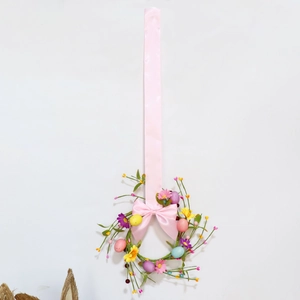 Easter egg wreath with spring flowers, greenery, and a long pink silk ribbon bow