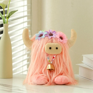 Pink Scottish Highland cow plush toy with flower crown and bell in natural light