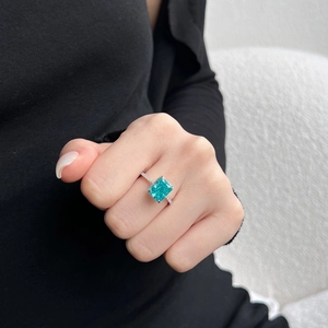Dettaglio anello in argento S925 con gemma verde dal taglio smeraldo sulla mano della modella