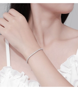 Close-up of a delicate 2.5mm silver tennis bracelet with sparkling moissanite on a wrist