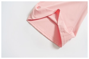 Detail of pink wide-leg pants showing premium double-stitched hem and elastic fabric texture