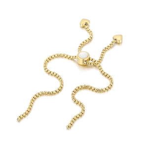 Detailed close-up of golden metal chain link with heart pendant and polished finish