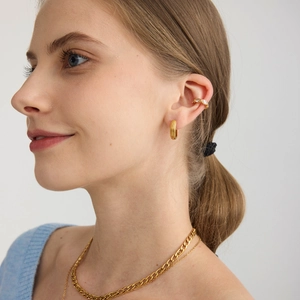 Modella che indossa orecchini a cerchio in acciaio inossidabile 18K e ear cuff con zirconi