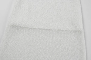 Detailed macro view of white textured knit fabric with soft boucle yarn for a cozy finish
